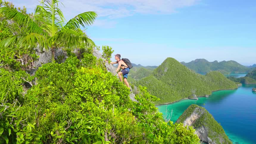 A man is hiking up a cliff in spring