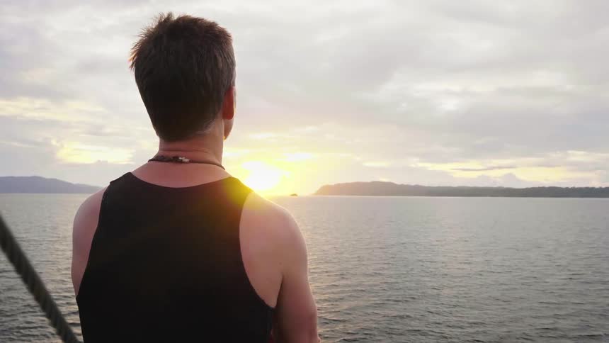 A man is by the ocean at dusk