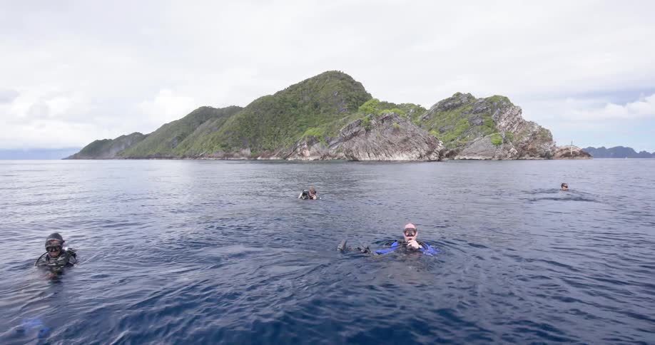 Four people floating in a lake before diving