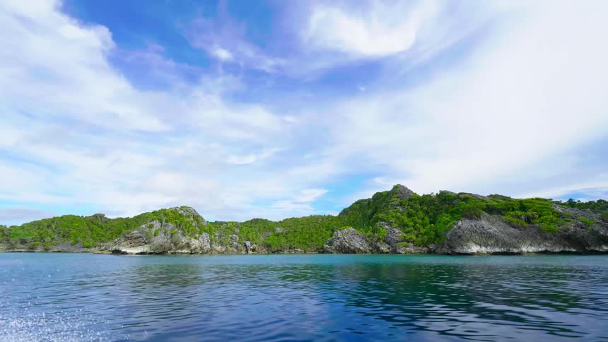 An island surrounded by water and a bright sky