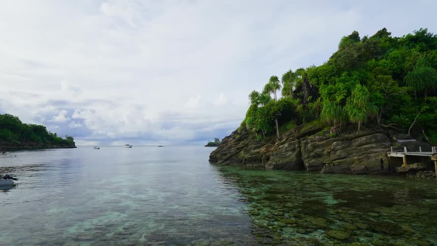 Empty canoes and kayaks float in clear ocean waters