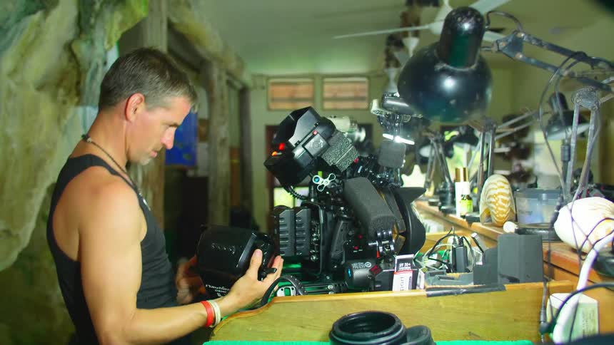A man taking apart a machine on a workbench