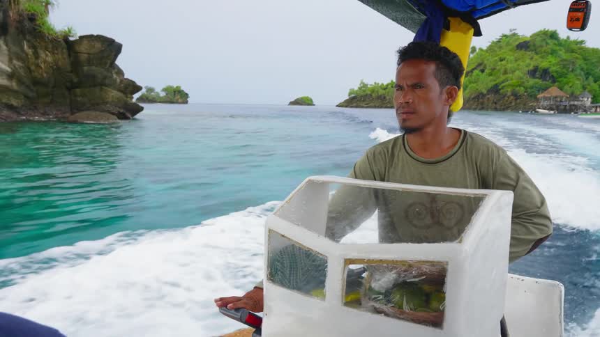 A man drives a boat across the bluegreen waters of the ocean on a cloudy day