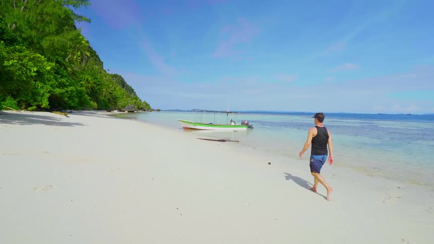 A man is walking on the beach