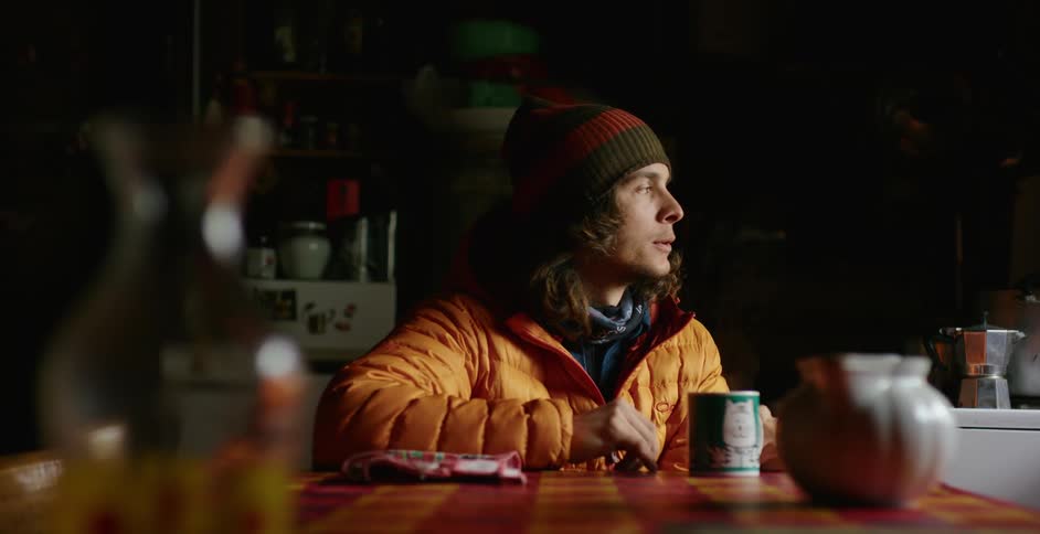A man is drinking a hot drink at the table
