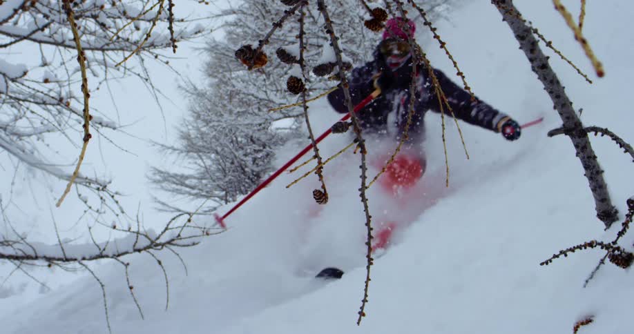 A skier speeding down a snowy mountainside during a snowstorm