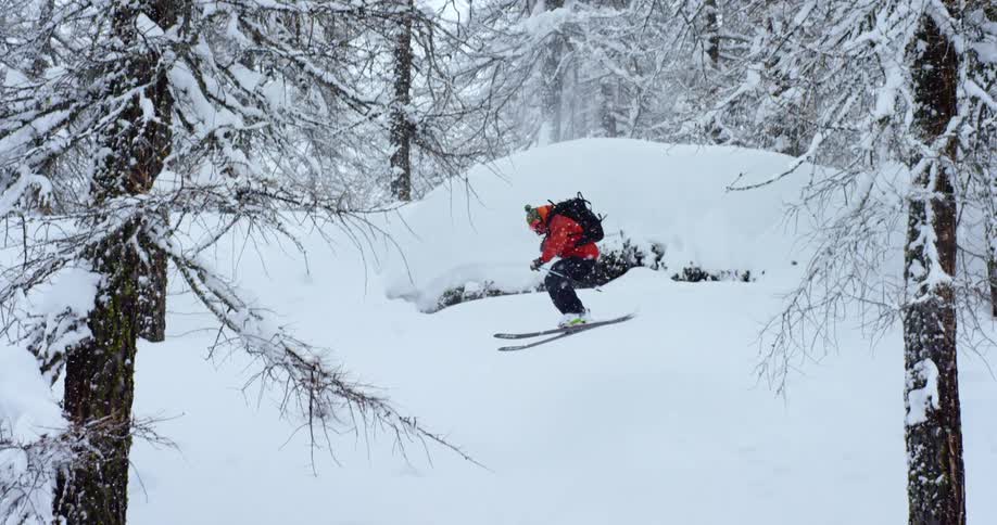 A man jumping on skis in the forest