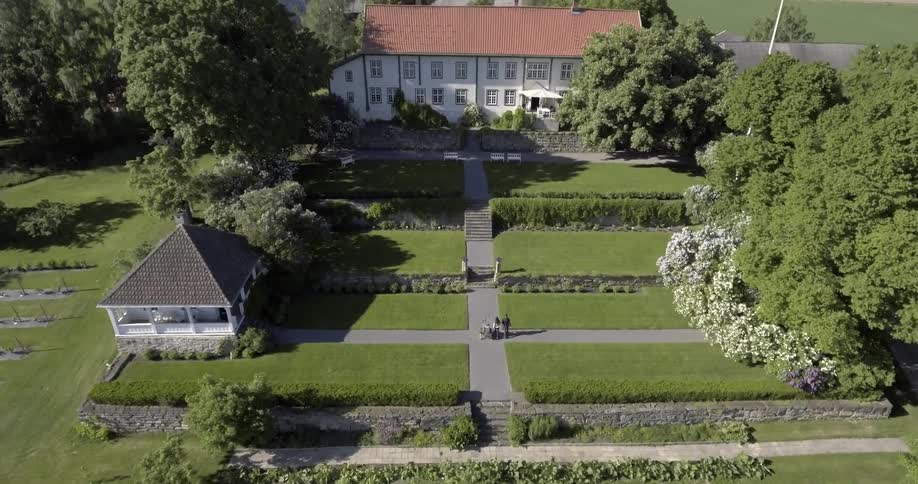 Overhead view of people walking towards a large estate in the country