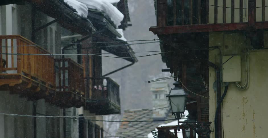 A city with buildings and snow falling
