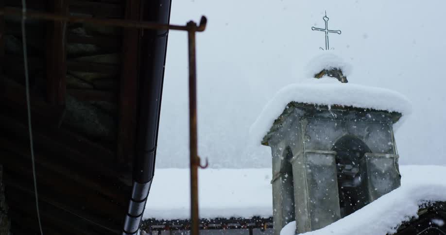 Snow falling on a church tower