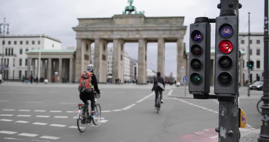 People riding bicycles ride across a large city intersection