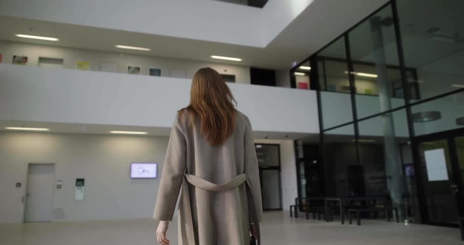 A woman is walking into a store