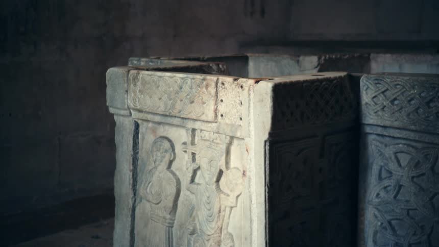 An ancient temple with carvings and a wall in the background