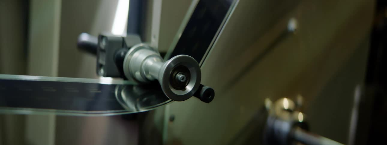 Filmstrip is moved along by spinning cylinders
