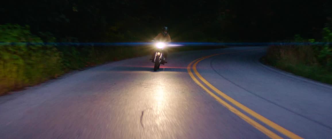 A person driving a motorcycle down a street