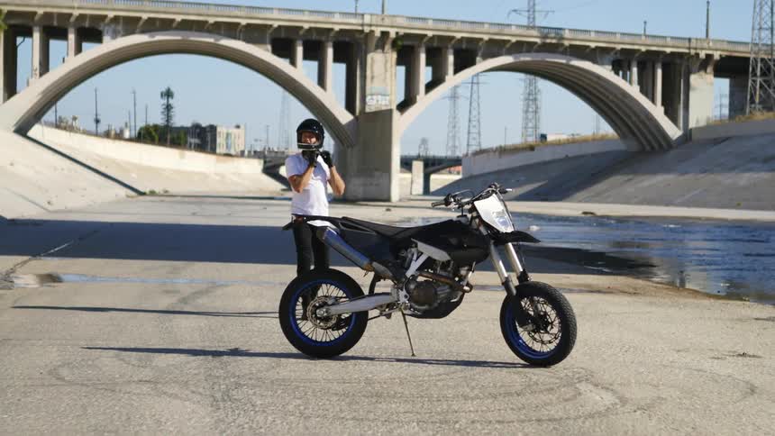 A man is walking towards his motorcycle