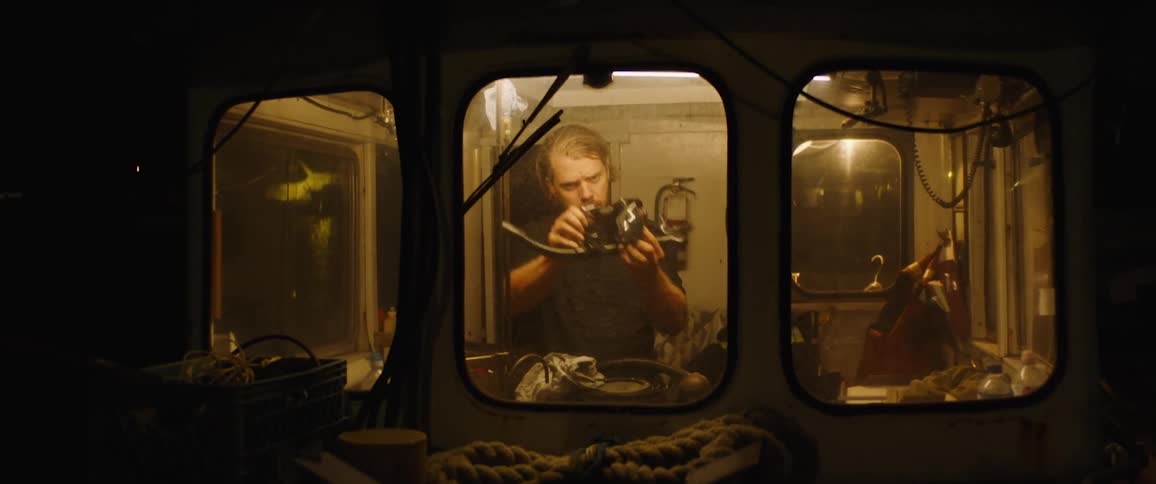 A man is cleaning stuff in the boat cabin