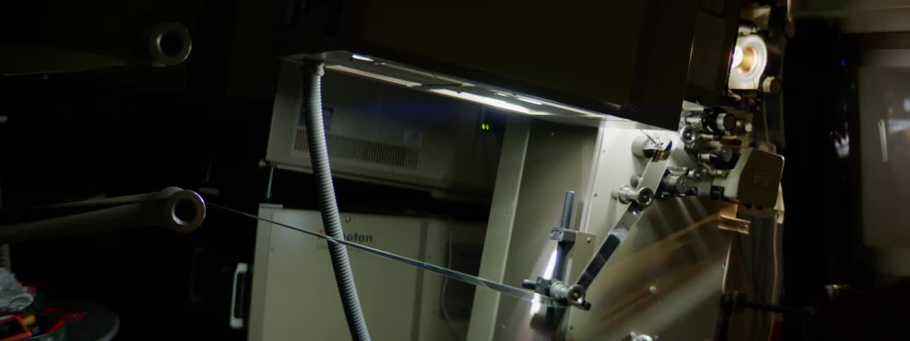 A projector plays a movie in a theater