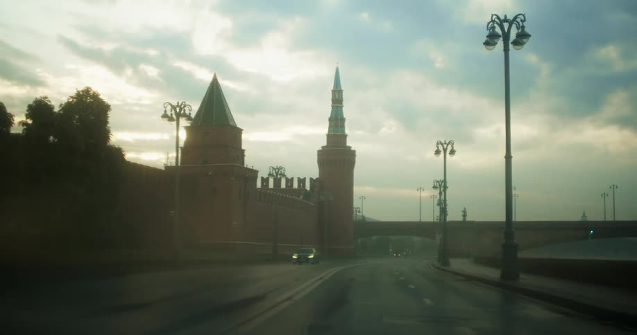 The steeple of a large building looms over a road with sparse traffic