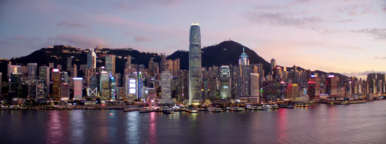 A city skyline near the coast with buildings and skyscrapers with the sky and clouds in the background