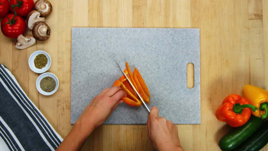 A man is using a knife to cut vegetables