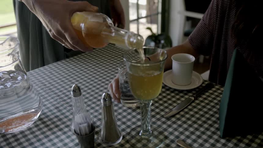 Person pouring a beverage into a glass
