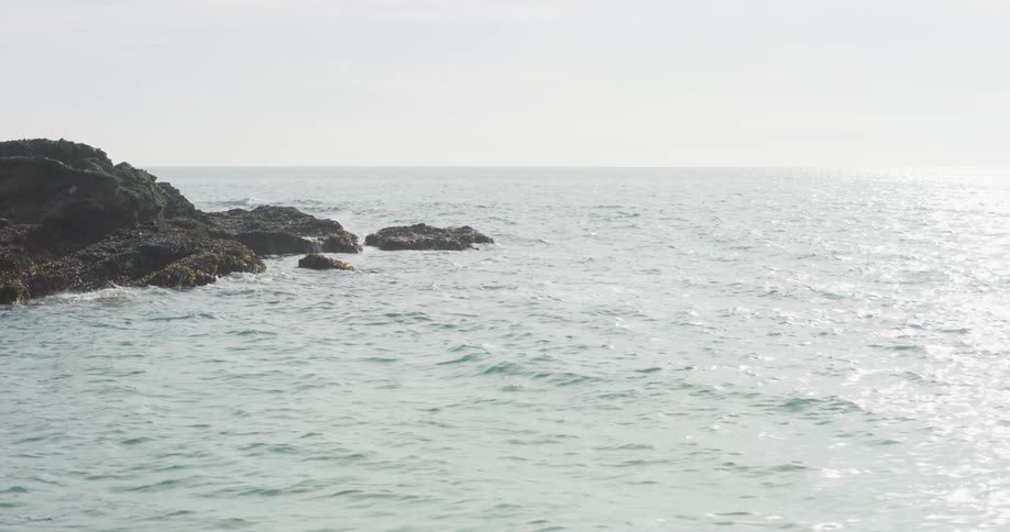 A rock formation on the ocean during the day