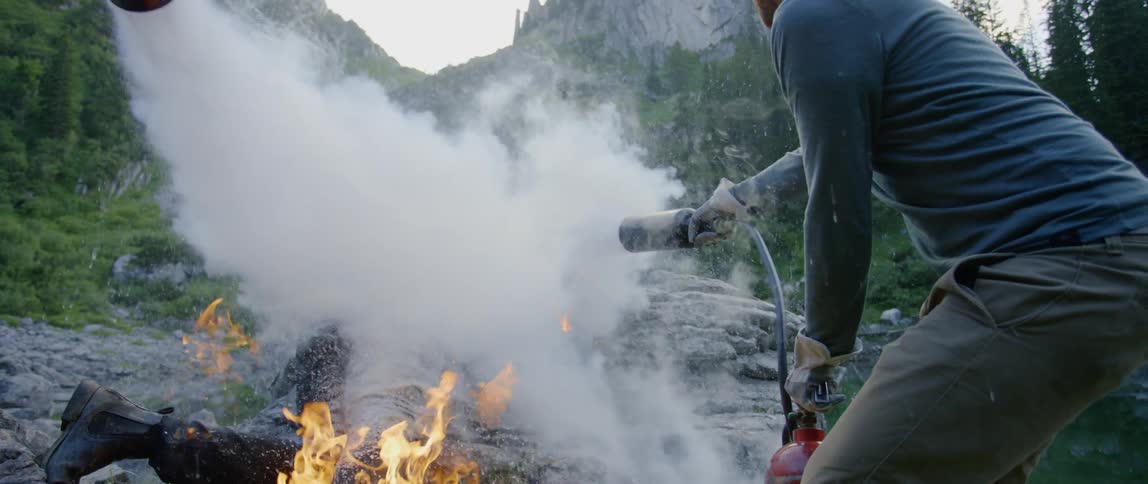 People use fire extinguishers to put out a man who is burning