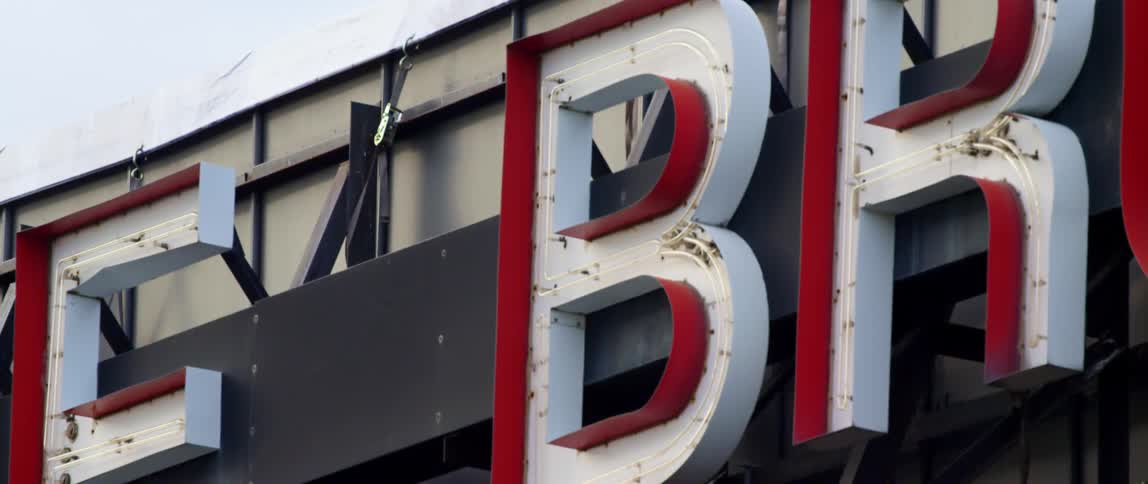 Sign lettering hanging on the side of a building