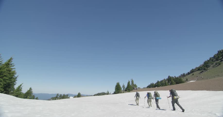 A group of people are hiking over a snow covered area