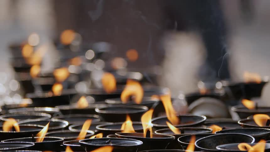 Many small pots that are aflame like candles as people walk by