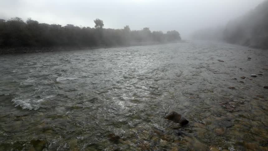 Shallow river flowing through some haze