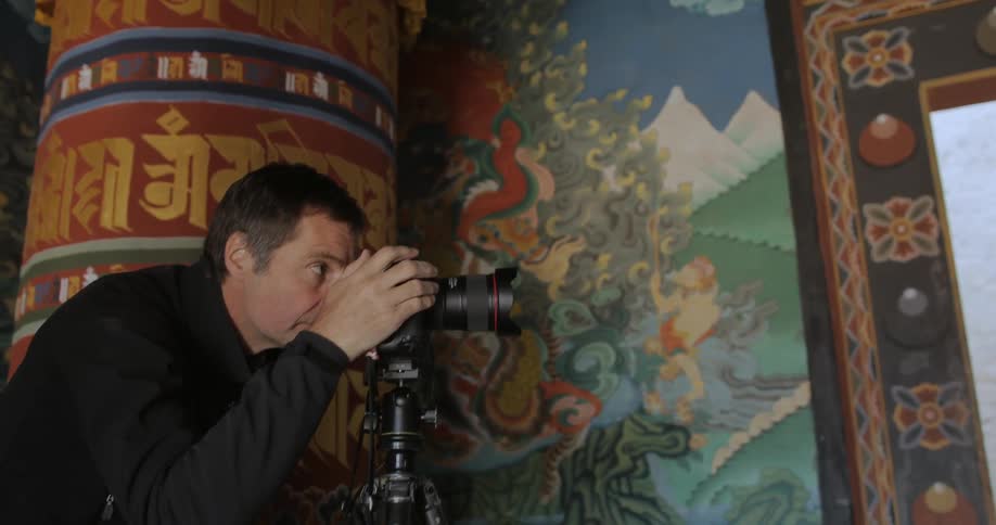A man takes photographs inside a temple