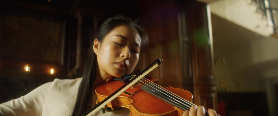 Female violinist plays a violin in a room
