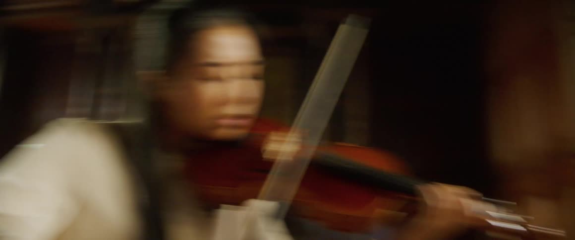 A woman is playing the violin indoors