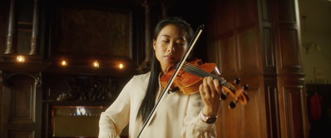 A woman is playing an instrument indoors