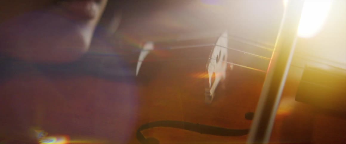 A woman is playing the violin indoors