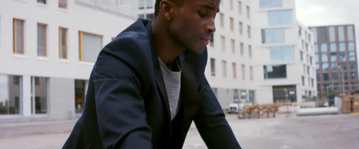 A man is standing in a city by his parked car