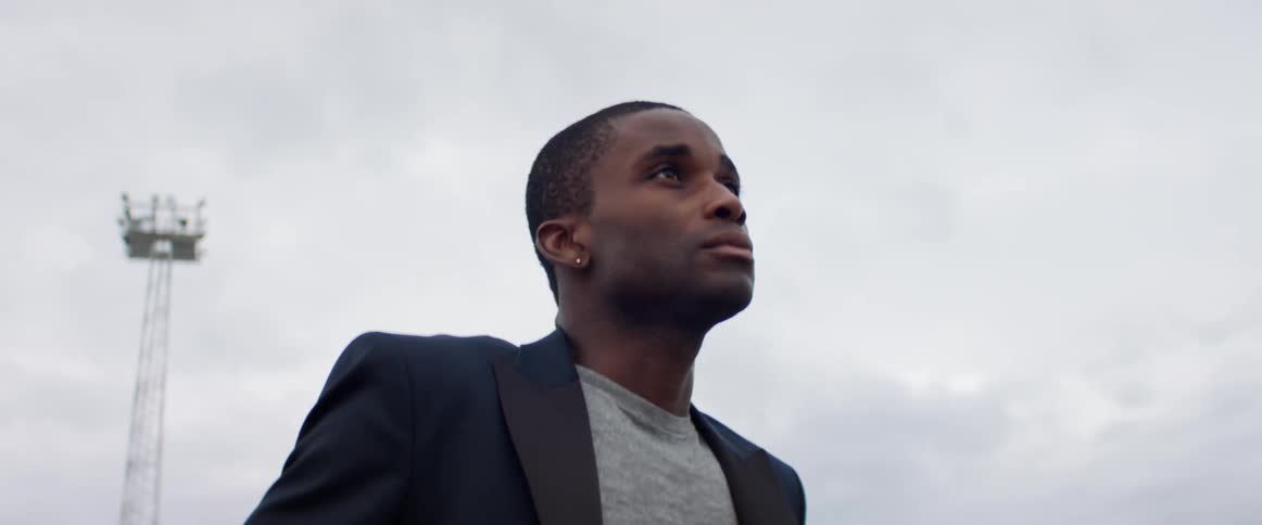 A man stands at a construction site and looks off in to the distance