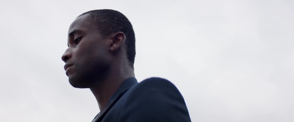 A man is standing outdoors on a cloudy day