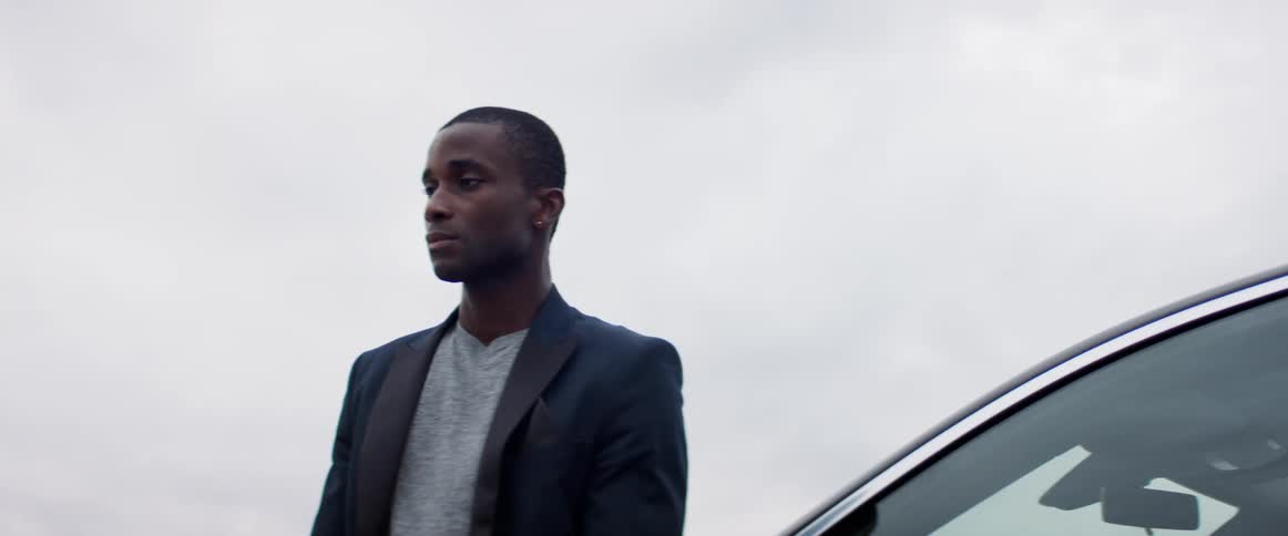 A man is standing by his car