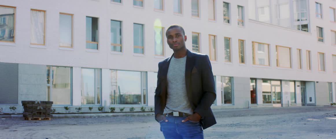 A man standing outside next to an apartment building