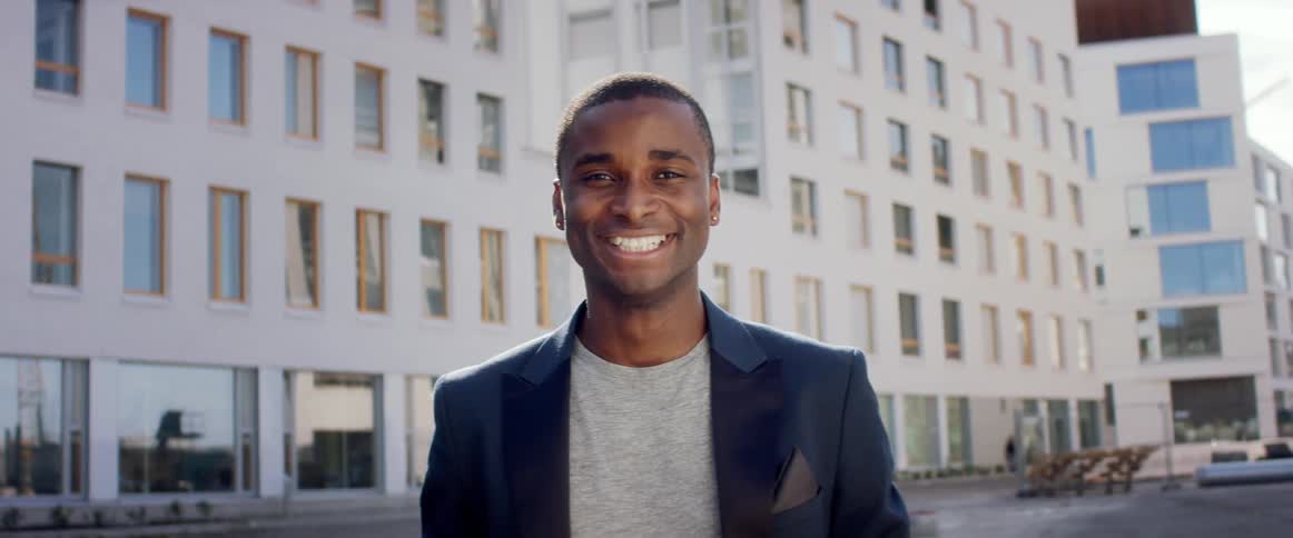 A man is by the building smiling