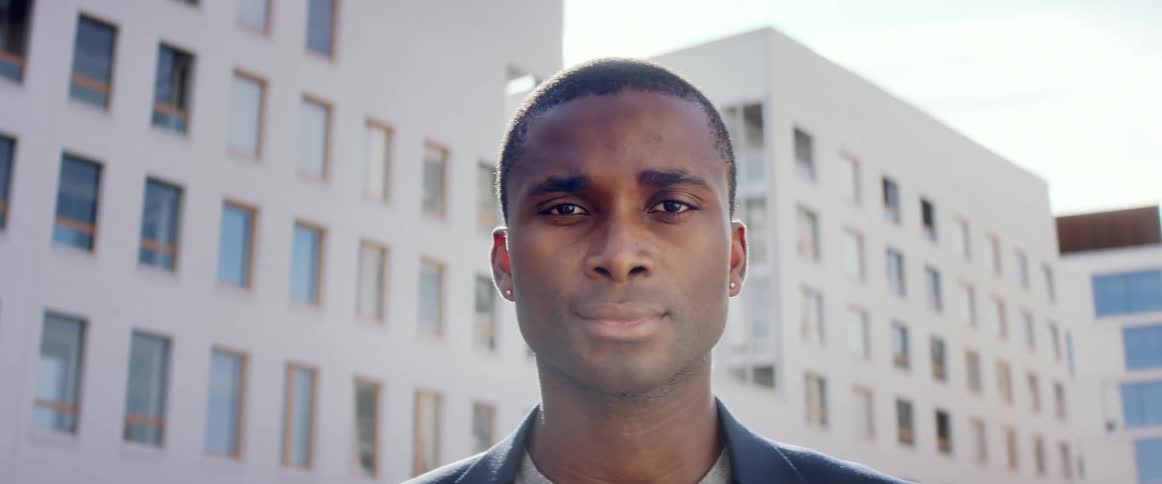 A man is standing in a downtown city