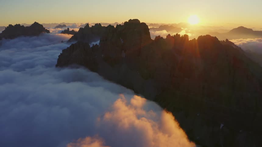The sun is setting in the horizon above the mountains