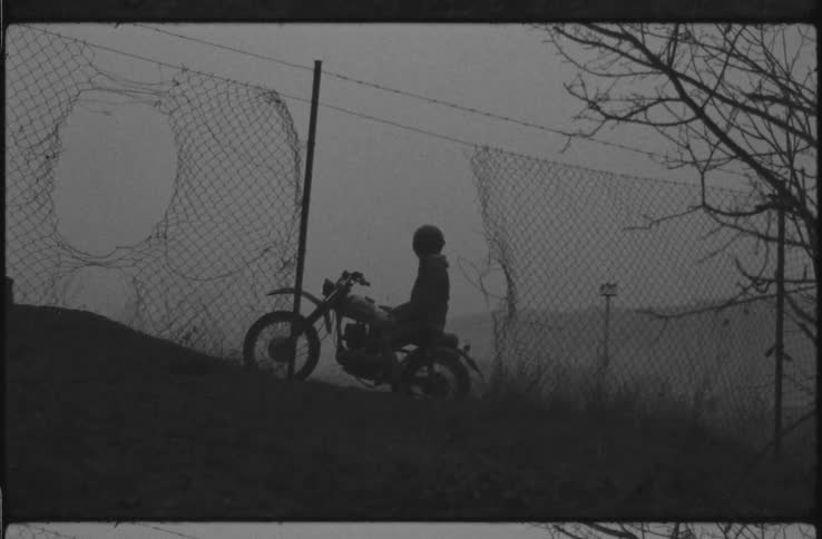 A person is sitting on his dirt bike on the hill