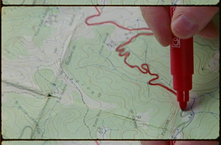 A person is tracing a line on the map