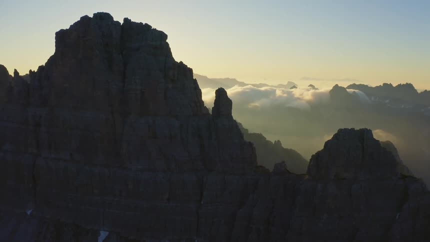 The sun shines bright over a mountain range