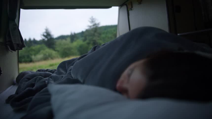 A woman sleeping while camping in nature