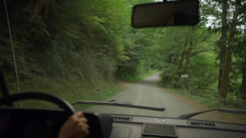 A woman is driving on the narrow road
